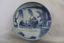 A Chinese blue and white dish, 20th century, painted with two sages and an attendant in a fenced