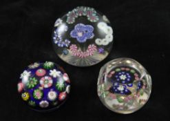 Three Clichy glass paperweights, 19th century, the first decorated with floral garlands, star cut