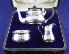 A cased George V silver three piece bachelor`s tea set, of plain bulbous form, Robert Pringle &
