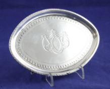 A George III silver oval teapot stand, with engraved monogram within a ribbon and swag cartouche,