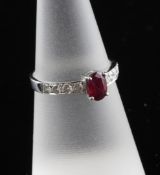 An 18ct white gold, ruby and diamond ring, with central oval cut ruby flanked by four diamonds on