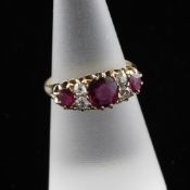 An Edwardian 18ct gold seven stone ruby and diamond dress ring, size L.