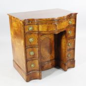A George III style satinwood and rosewood crossbanded serpentine kneehole desk, with brushing