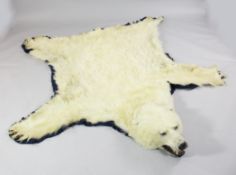 A 20th century polar bear skin rug, with open mouth and claws on a felt backing, 6ft 8in.