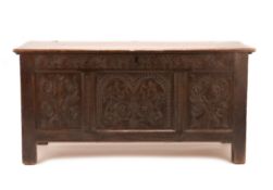 A CHARLES II PANELLED OAK COFFER, CIRCA 1680, the twin plank top above a lunette and stiff leaf