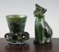 A C.H. Brannum pottery cat and a six handled tyg, 1901-04, the seated cat with brown and green