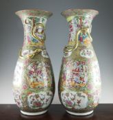 A pair of large Chinese Canton decorated famille rose vases, 19th century, each painted with