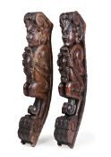 A PAIR OF LARGE ELM AND OAK CARVED BRACKETS, EARLY 17th CENTURY, of curved crouching satyrs
