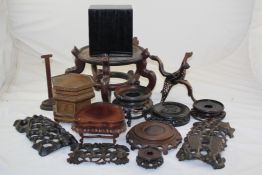 A collection of thirteen Chinese and other wood stands, and one cover