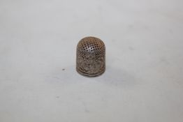 A 16th century silver thimble, the shaped cartouche with the monogram MT, .075in.