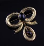 A Victorian style 9ct gold and cabochon garnet brooch, of engraved bow design with drop, width 2in.