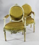 A pair of Louis XVI style fauteuils, with oval backs, open arms and fluted tapering supports
