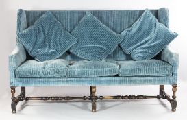 An 18th century Provincial French wingback settee, with blue stripe upholstery and turned walnut