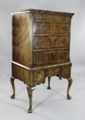 An early 18th century style featherbanded walnut chest on stand, fitted four graduated drawers