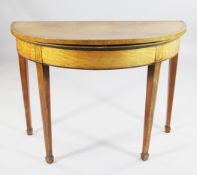 A George III demi lune satinwood and rosewood crossbanded folding card table, with square section