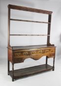 An 18th century oak dresser base, with open plate rack over three frieze drawers with pot space