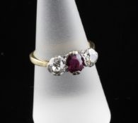 A 1940`s 18ct gold three stone ruby and diamond ring, the central oval cut ruby flanked by old cut