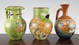 Three C.H. Brannam pottery `fish` jugs, c.1889-94, comprising a jug with fish head spout and