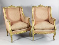 A pair of French Louis XV design carved giltwood wingback armchairs, with C scroll carved crest rail