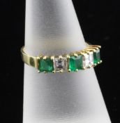 An 18ct gold, emerald and diamond five stone half hoop ring, size N.