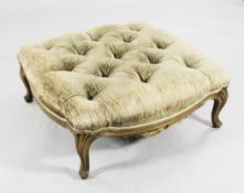 A large square early 20th century serpentine shaped foot stool, with button fabric and stylised
