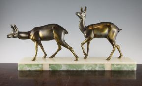 A French Art Deco patinated metal figure group, of two deer, on a rectangular onyx base marked