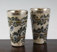 A pair of Doulton Lambeth stoneware silver mounted beakers, by George Tinworth, c.1877, decorated