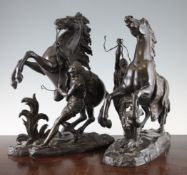 After Coustou. A pair of bronze Marly horses, on oval naturalistic bases, 14in.