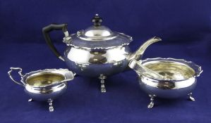 A George V silver three piece tea set, of squat circular form, with cut rims, on hoof feet, Wilson &