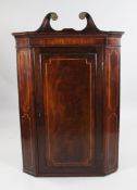 A 19th century mahogany and boxwood inlaid hanging corner cupboard, with swan neck pediment and