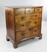 An early 18th century and later walnut and elm chest, of three short and three long graduated