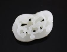 A 14ct gold mounted free form jadeite brooch, carved with foliate decoration, 2in