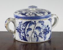 A Dutch Delft blue and white posset pot and cover, decorated with flowers and foliage, with a pair