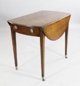 A George III `plum pudding` mahogany oval Pembroke table, with single bow end door, on tapered