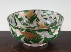 A Japanese Kutani porcelain bowl, c.1900, painted with numerous cranes in flight on a green