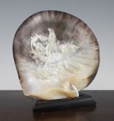 An early 20th century carved mother of pearl shell, depicting fishermen at sea, 9in.