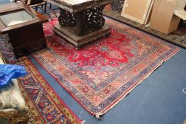 A Tabriz carpet, with central foliate medallion in a field of scrolling foliate motifs on a madder