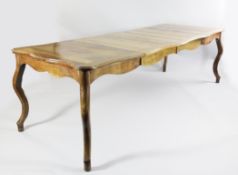 A provincial French oak dining table, of serpentine outline, on scrolling legs, 7ft 8in. x 3ft