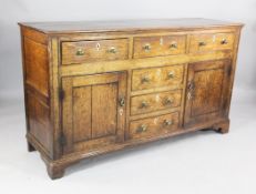 An 18th century oak dresser base, fitted with three frieze drawers over three central dummy drawers,