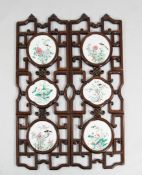 A pair of Chinese rosewood and famille rose porcelain mounted wall panels, late 19th / early 20th