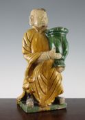 A Chinese Sancai pottery figure, in Ming style, wearing robes and holding an urn, 15in. (38.3cm)