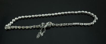 A modern 9ct white gold and diamond set articulated line bracelet.