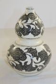 A Chinese Cizhou style pottery double gourd vase, decorated with incised black flowers on a cream