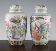 A pair of Chinese famille rose tall ovoid jars and covers, early 20th century, each painted with the