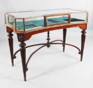 A late 19th century glazed bijouterie table, rectangular top with concave sides and canted corners
