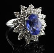 An 18ct white gold, sapphire and diamond oval cluster dress ring, with raised central oval cut
