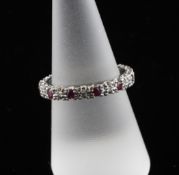 An 18ct white gold, ruby and diamond set full eternity ring, size O.