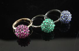 An unusual suite of three 18ct blackened or yellow gold ruby, sapphire or emerald set dress rings,