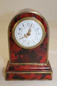 An early 20th century red tortoiseshell mantel timepiece 7in. An early 20th century red