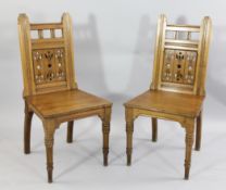 A pair of oak Arts and Craft hall chairs A pair of oak Arts and Craft hall chairs, in the manner